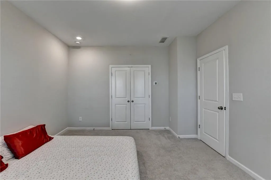 Carpeted bedroom with visible vents and baseboards