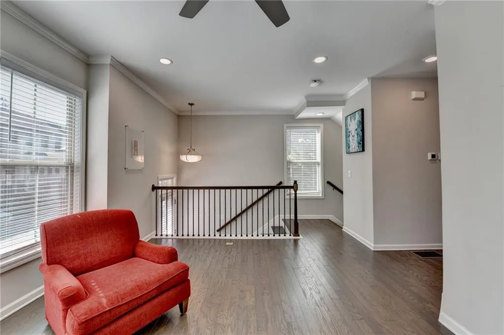 Living area with recessed lighting, an upstairs landing, baseboards, ornamental molding, and dark wood finished floors