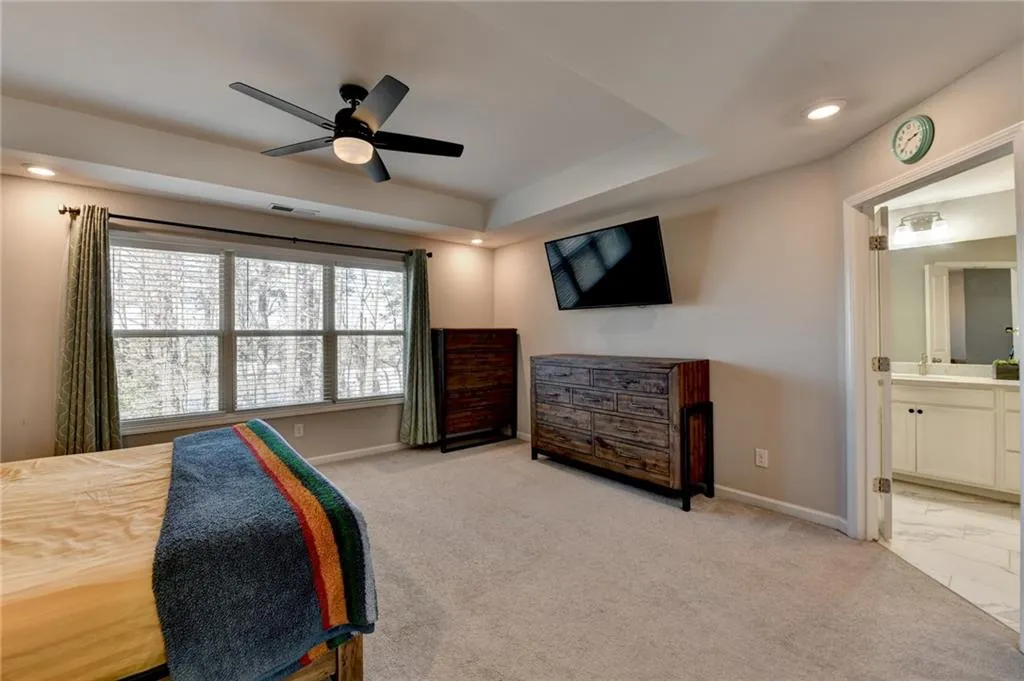 Bedroom featuring recessed lighting, baseboards, connected bathroom, and light colored carpet