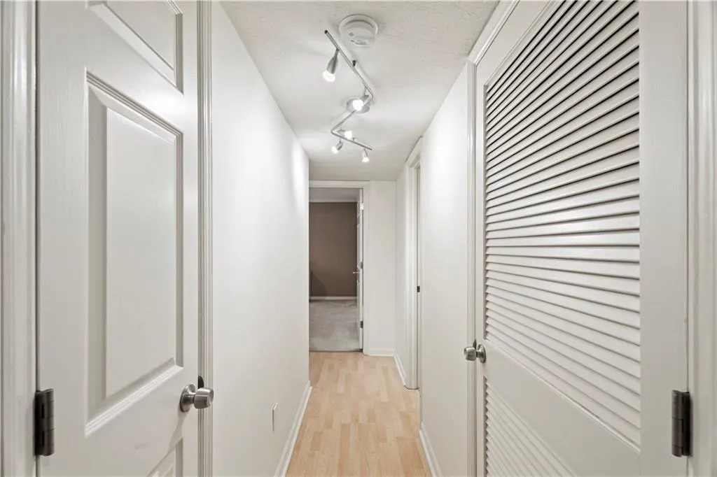 Hall with light wood-type flooring and rail lighting Hall with light wood-type flooring and rail lighting