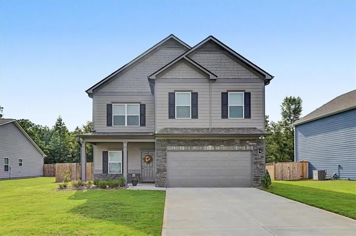 Two-story property featuring a gabled roofline, stone facade accents, and a covered porch