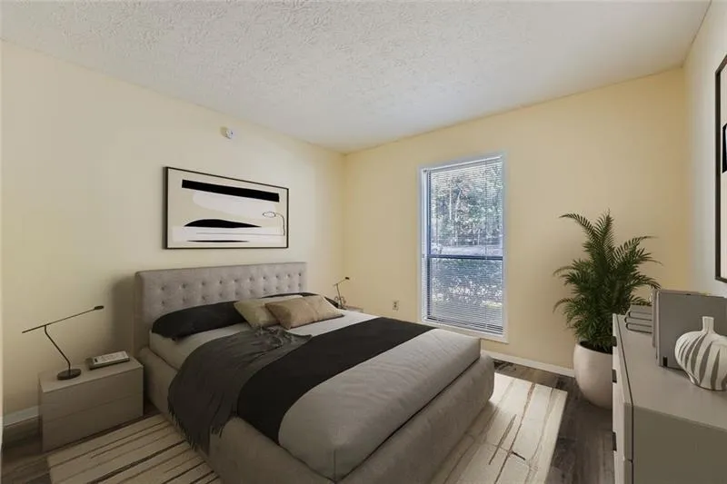 Bedroom featuring dark wood-style flooring and a textured ceiling