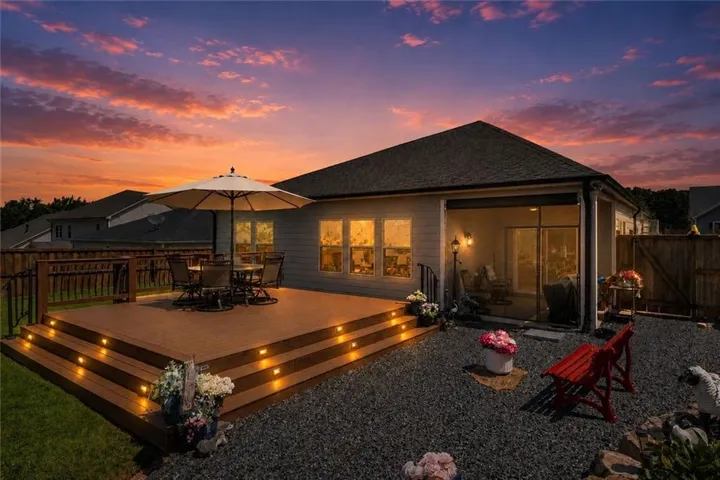 Expansive multi-level wood-finish deck with integrated lighting, a screened patio, and a gravel hardscaped area