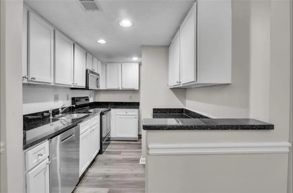Kitchen featuring electric range oven, white cabinets, dishwasher, recessed lighting, and light wood finished floors