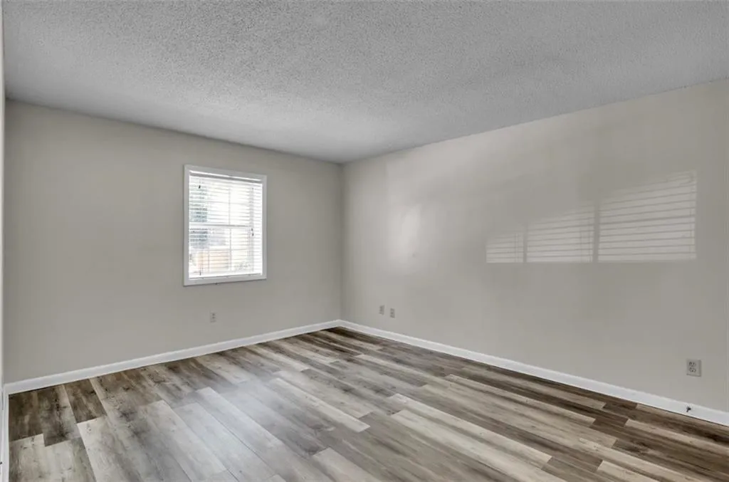 Unfurnished room featuring a textured ceiling and light wood-type flooring