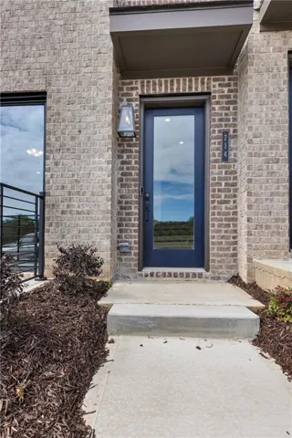 Brick exterior with dark-framed windows and a glass-paneled entry door
