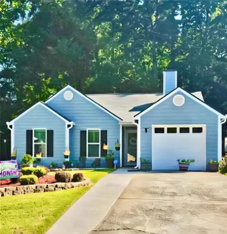 Single-story residence featuring blue siding, a white garage door, and a paved driveway