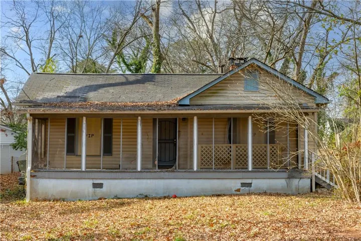 View of front of home featuring crawl space, a large porch, and roof with shingles