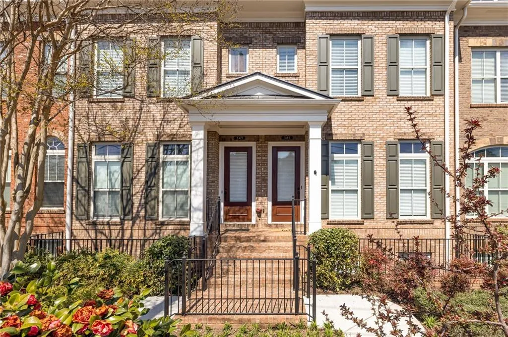 View of front of property featuring brick siding and a gate