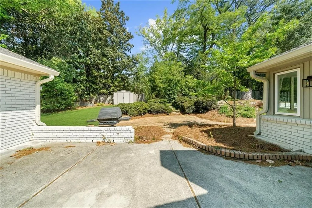 View of yard with an outbuilding, a patio, and a storage shed