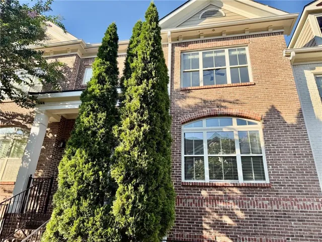 Brick exterior with arched window detailing, white window frames, and decorative gables