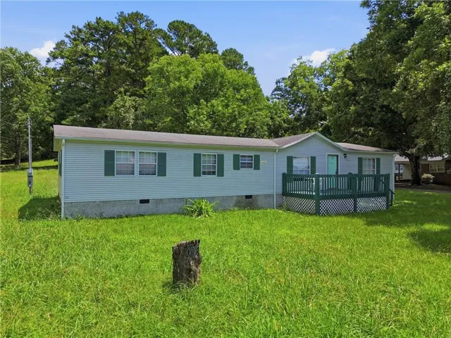 Light blue siding exterior with green shutters, a green front deck, and a contrasting turquoise front door