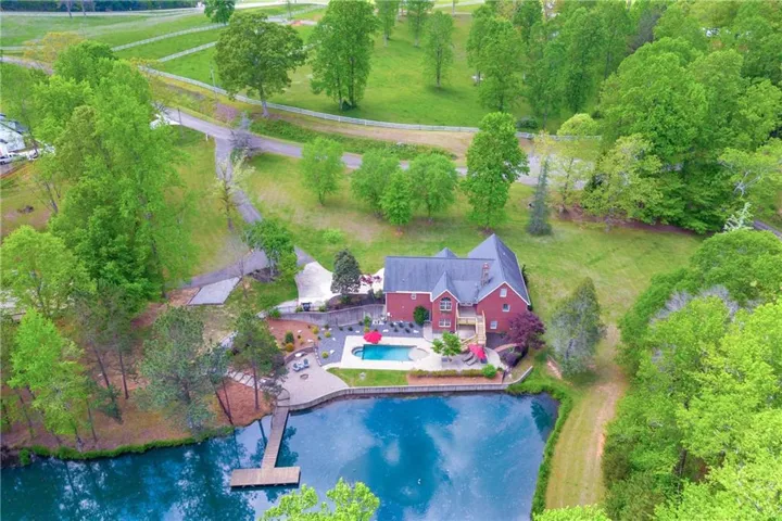 Aerial view of property and surrounding area featuring a pool area