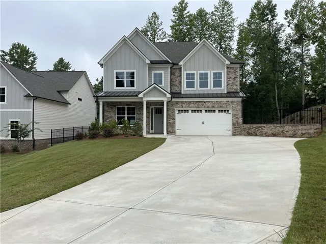 Two-story colonial featuring a stone and siding exterior with a welcoming front entry portico