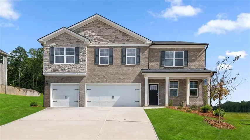 Two-story residence featuring a stone and brick façade, a covered front entry with columns, a two-car garage, and a concrete driveway