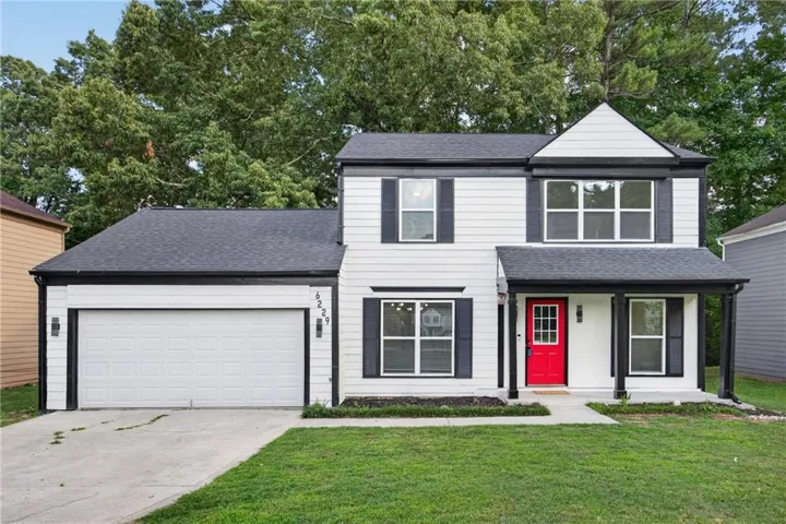 Two-story residence featuring white siding, a contrasting dark roof, and black shutters