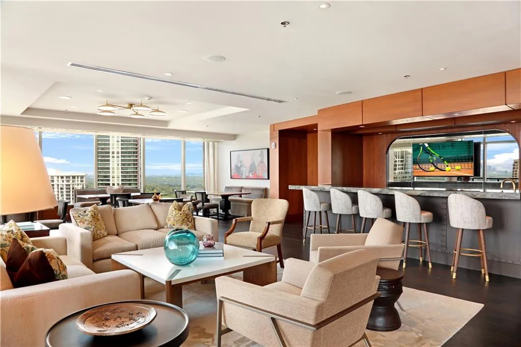 Living room with a raised ceiling, dark wood-style floors, and recessed lighting