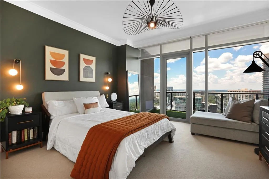 Bedroom featuring expansive windows, carpet, ornamental molding, access to outside, and a city view