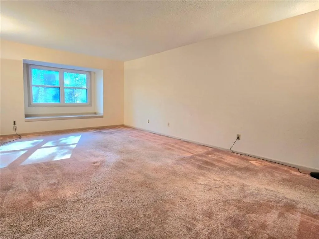 Empty room with carpet flooring and a textured ceiling