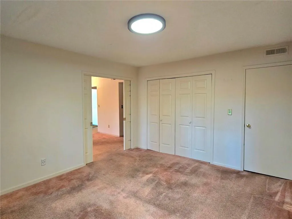 Unfurnished bedroom with carpet flooring and a closet