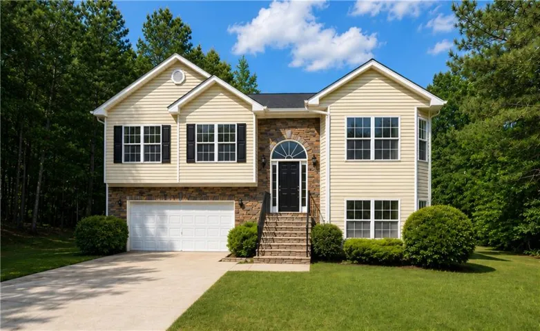 Cream-colored siding exterior with stone accents and a prominent arched entryway