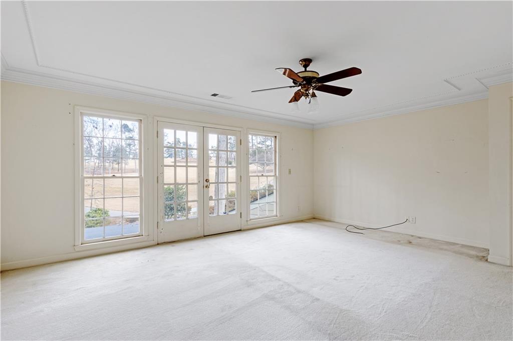 Master bedroom featuring ornamental molding, a wealth of natural light, french doors and ceiling fan