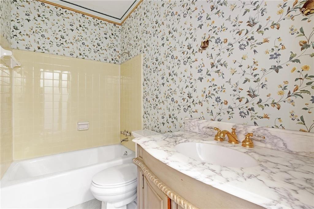 Full bathroom with tiled shower / bath, vanity, and toilet