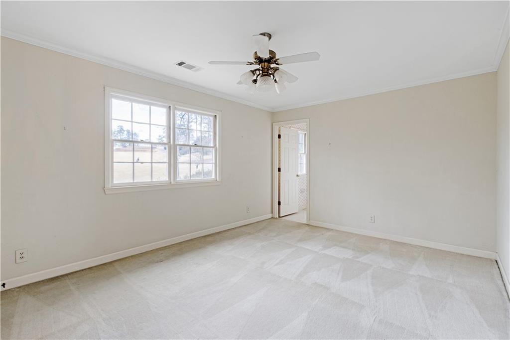 Bedroom featuring ceiling fan, ornamental molding and tons of natural light