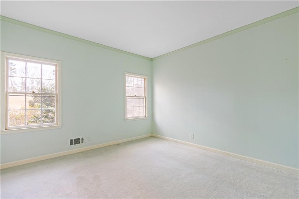 Bedroom with a wealth of natural light and crown molding