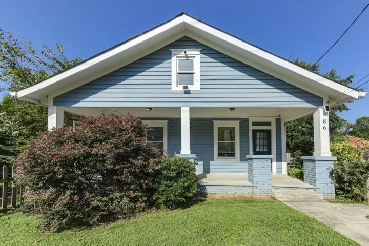 Blue horizontal siding exterior with a prominent gabled roofline and white trim