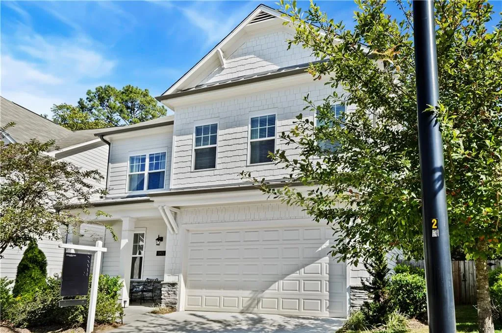 View of front of property featuring an attached garage, driveway, and covered porch