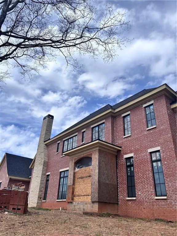 Back of property with brick siding and a chimney