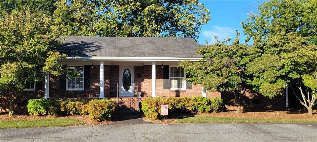 View of front of property with covered porch and brick siding