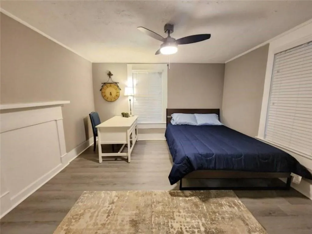 Bedroom with crown molding, baseboards, and wood finished floors