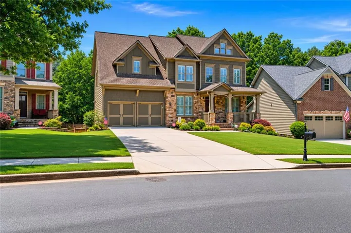 Front Exterior - Beautifully maintained Acworth home with stone accents, fresh curb appeal, and a welcoming front porch. The wide driveway and landscaped front yard create an inviting first impression.