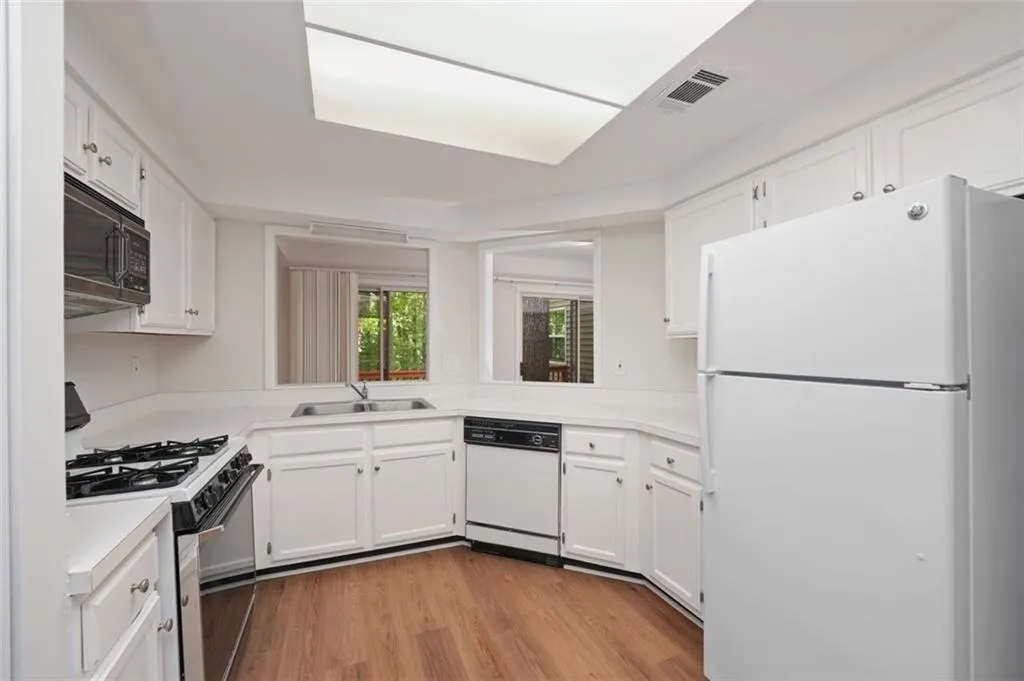 Generous size kitchen with tons of newly painted cabinetry and hardware and new flooring