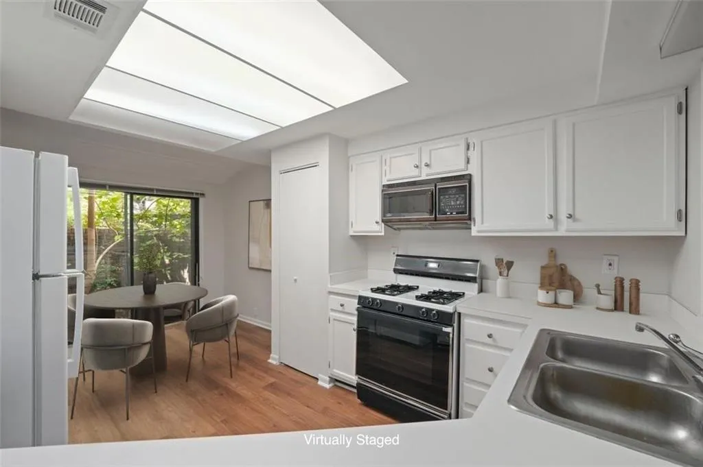 Kitchen and breakfast room overlooking private Front Courtyard (virtually staged)