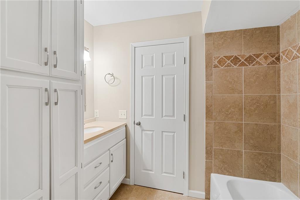 Bathroom with tile flooring, bathtub / shower combination, and vanity