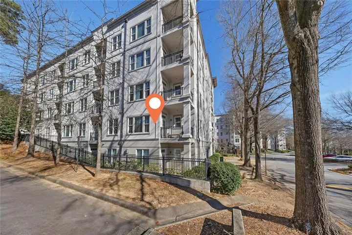 Multi-story building exterior with multiple balconies and perimeter fencing