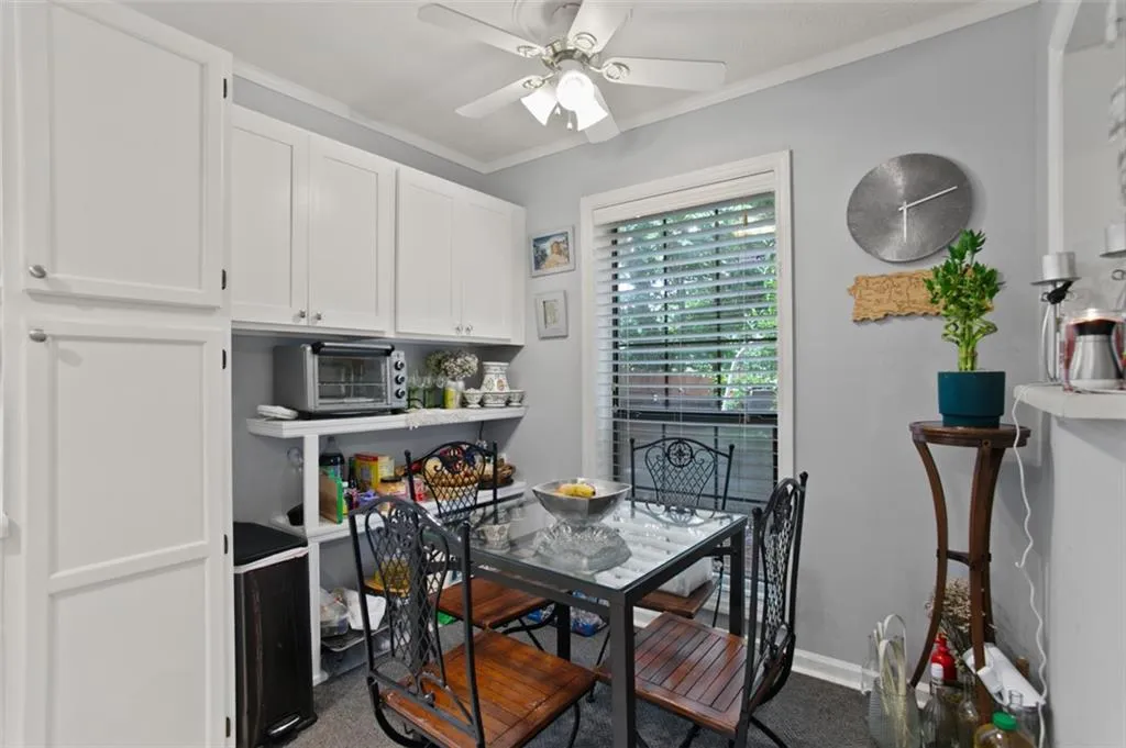 Dining room featuring a ceiling fan, ornamental molding, and carpet floors