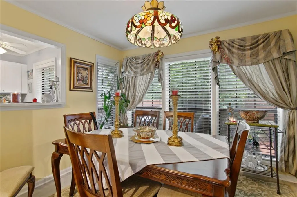 Dining area with ornamental molding, wood finished floors, and ceiling fan
