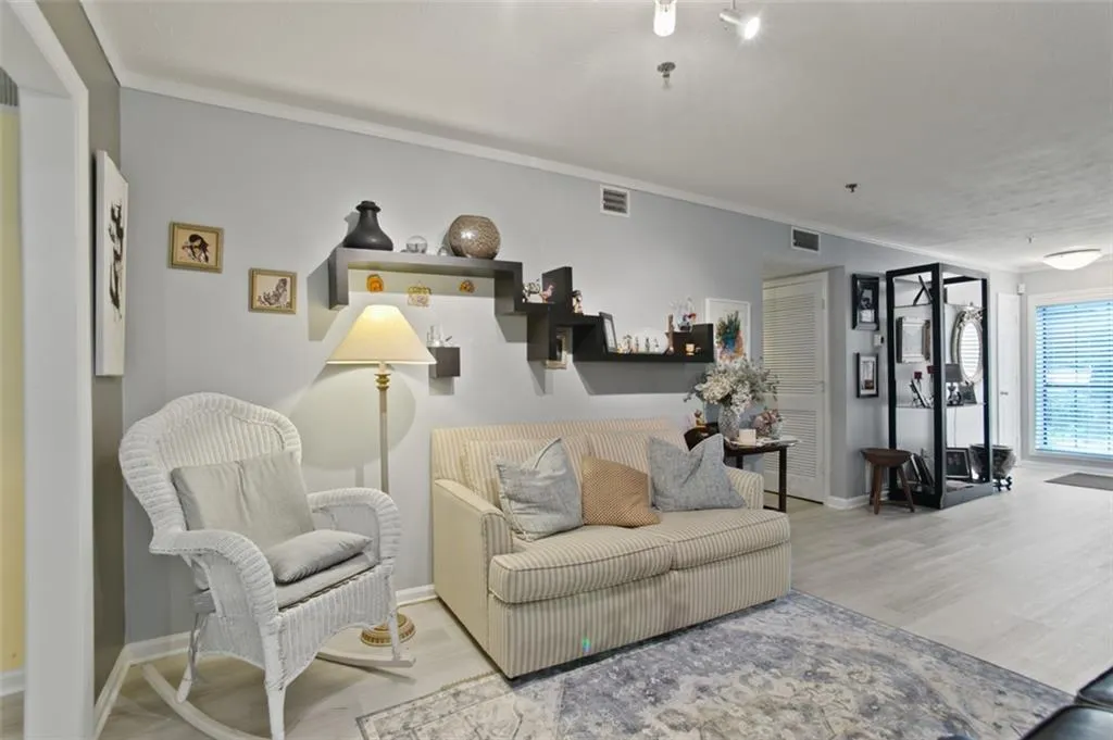 Living area featuring wood finished floors and crown molding