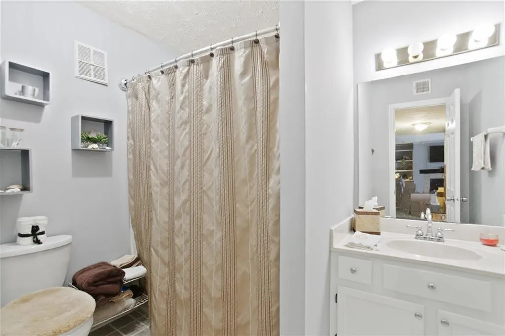 Full bath featuring vanity and curtained shower