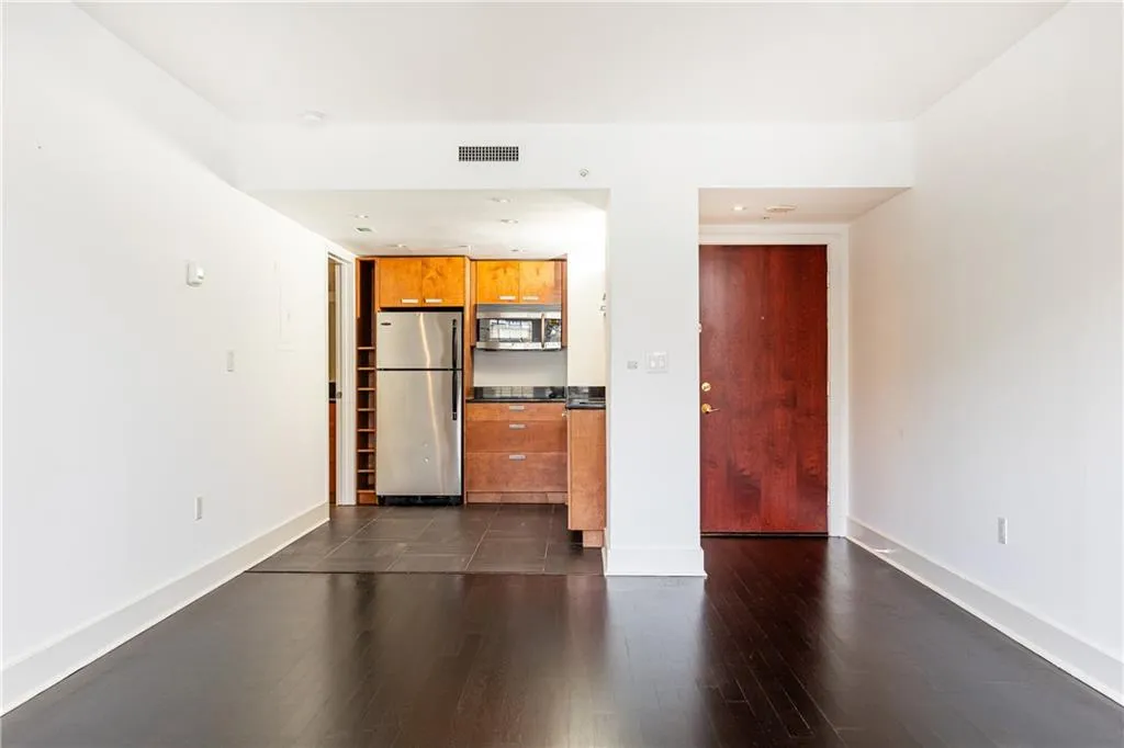 Unfurnished living room with dark wood-style flooring and recessed lighting