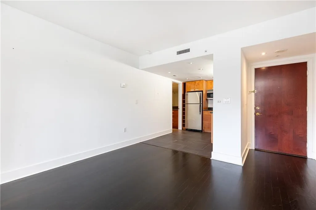 Unfurnished living room with dark wood-style flooring and recessed lighting