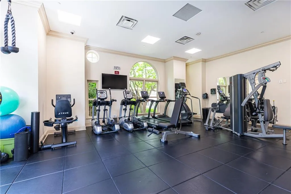 Workout area featuring ornamental molding and baseboards