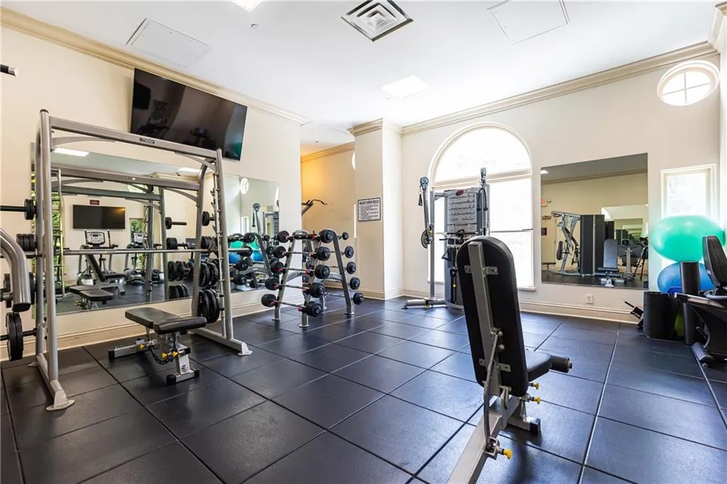 Gym with ornamental molding and baseboards