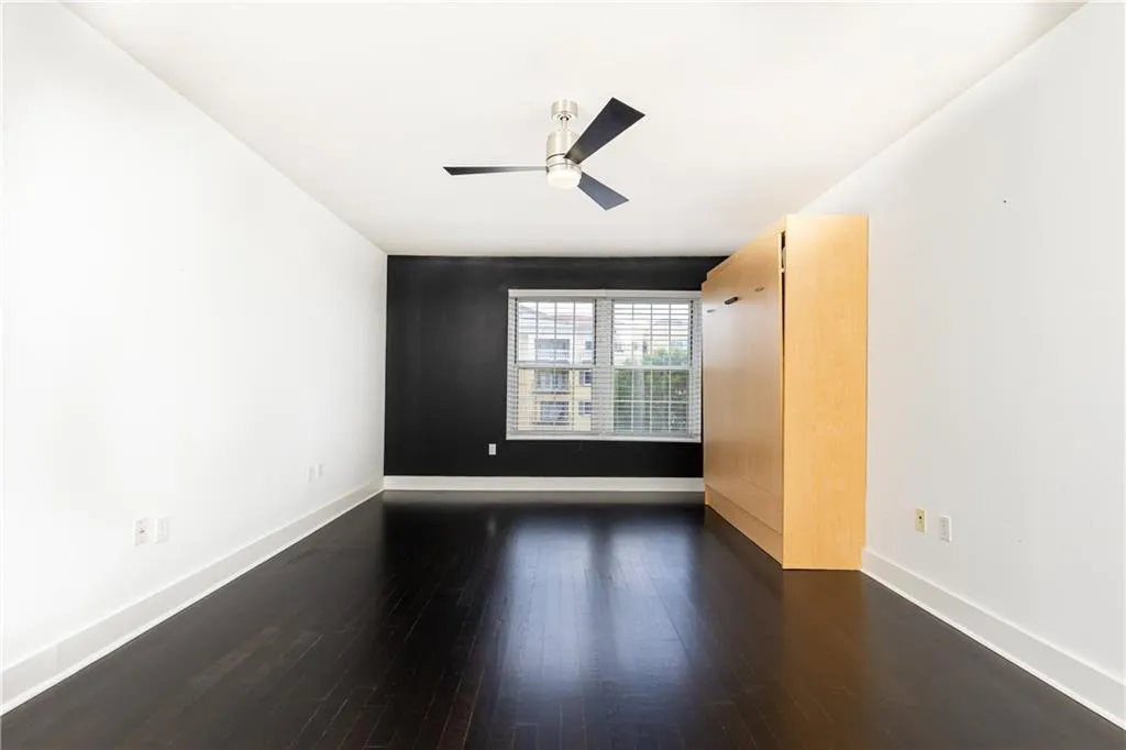 Empty room featuring wood finished floors and a ceiling fan