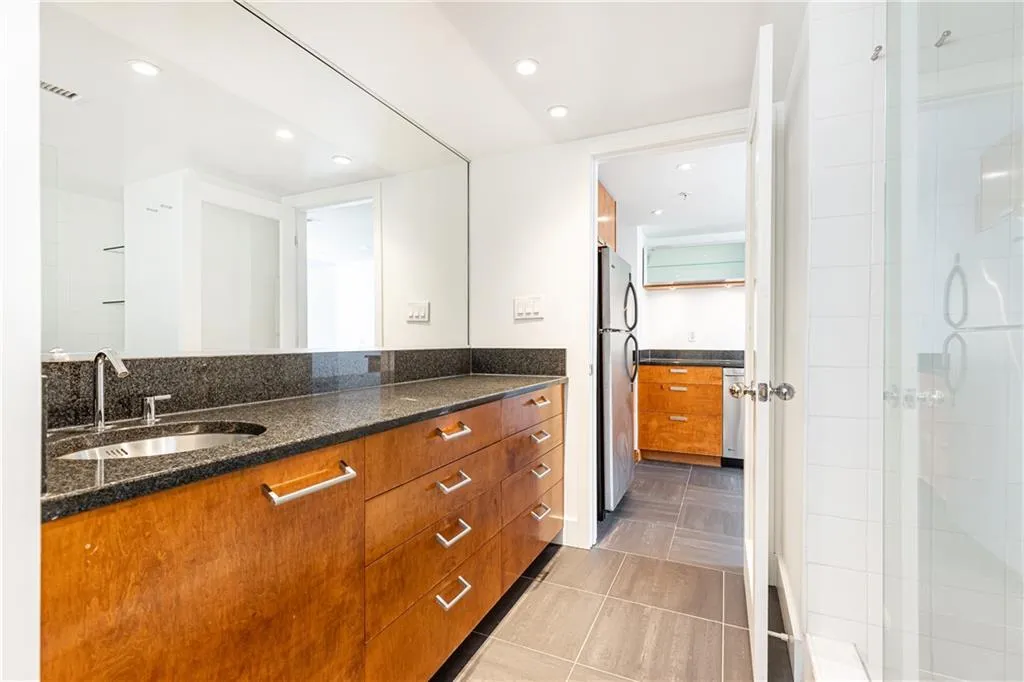Full bathroom featuring vanity, tile patterned floors, a tile shower, and recessed lighting