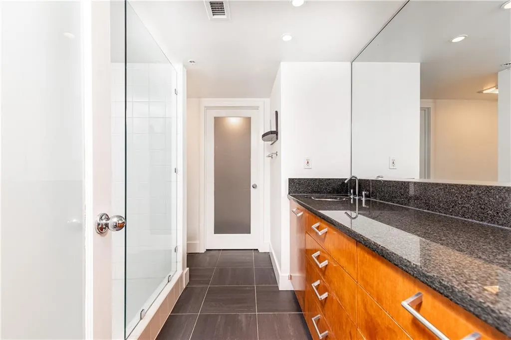 Full bathroom with vanity, a shower stall, and recessed lighting